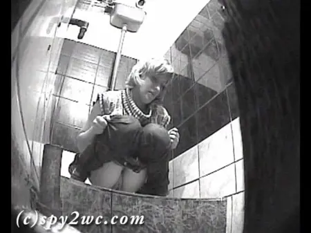 A hidden camera in the toilet of a nightclub shoots like women pierced
